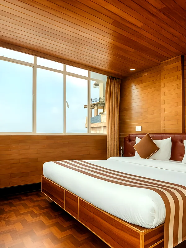 Deluxe Double Bedroom at Hotel Apsara Darjeeling with a mountain view, double bed — wood-panelled bedroom